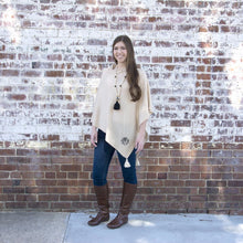 Load image into Gallery viewer, Model wearing a taupe tassel poncho